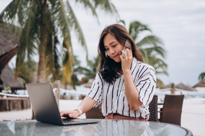 ผู้บริหารหญิงทำงานผ่านแล็ปท็อปริมทะเล สะท้อนเทรนด์ Digital Nomad 2026