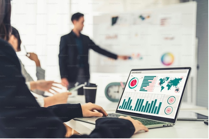 ทีมธุรกิจกำลังวิเคราะห์ข้อมูลลูกค้าจาก dashboard บนหน้าจอ เพื่อนำไปใช้วางกลยุทธ์การตลาด