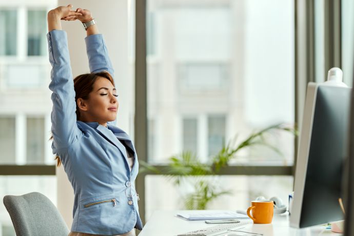 พนักงานออฟฟิศยืดแขนพักระหว่างทำงานในพื้นที่ Workplace Wellness