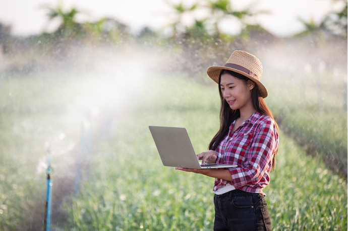  เกษตรกรหญิงตรวจสอบระบบรดน้ำอัตโนมัติในแปลงปลูก ตามแนวทางเกษตรแม่นยำ (Precision Farming)